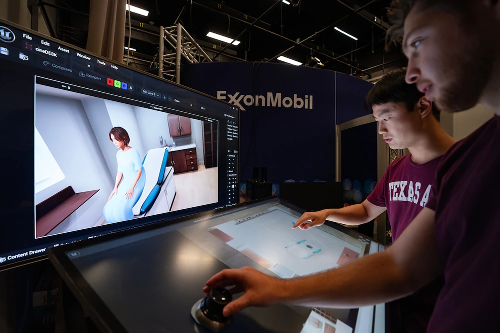 Two students interacting with a virtual model of a woman in a hospital room
