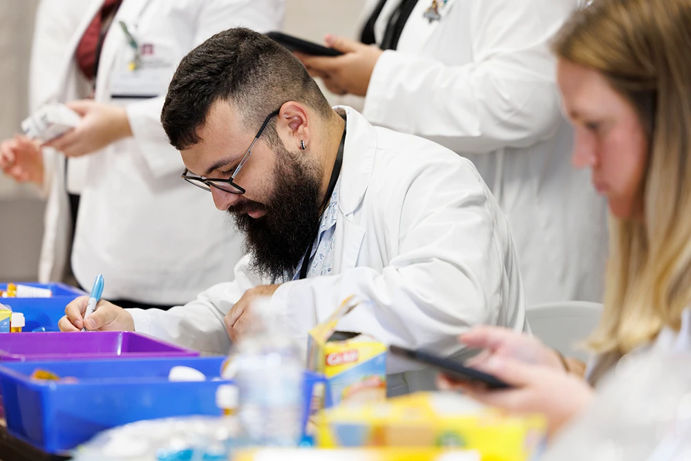 Students in labcoats take notes on Disaster Day