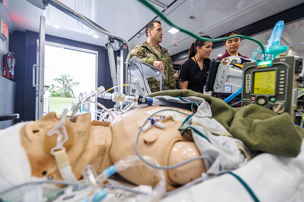 Medical simulation mannequin is connected to monitoring devices in a triage tent