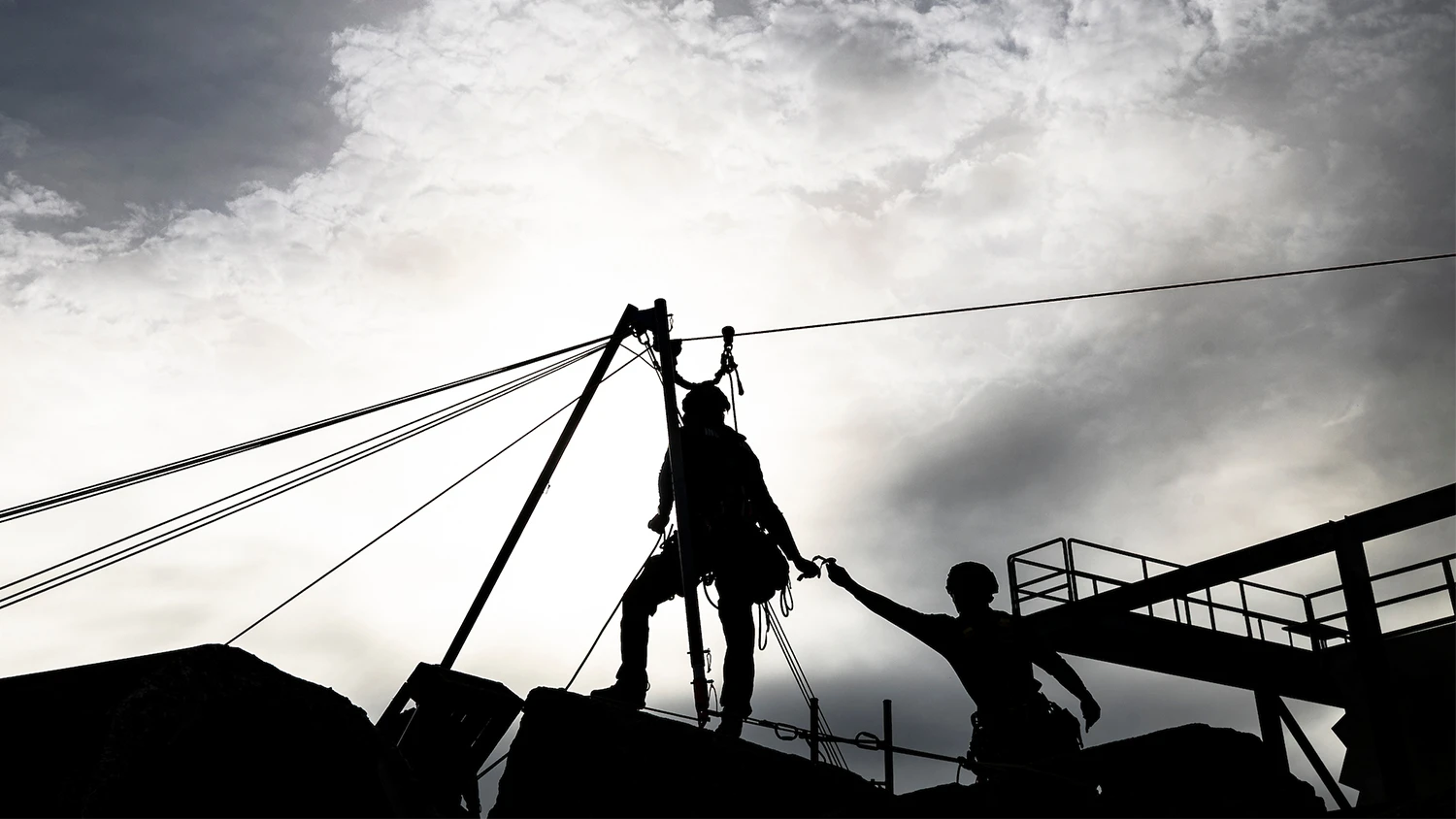 Search and rescue first responders silhouetted against a stormy sky