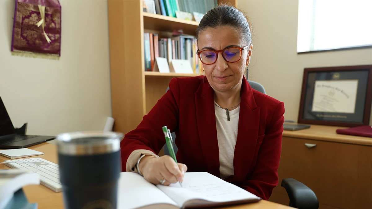 Dr. Davlasheridze writing in a notebook in her office